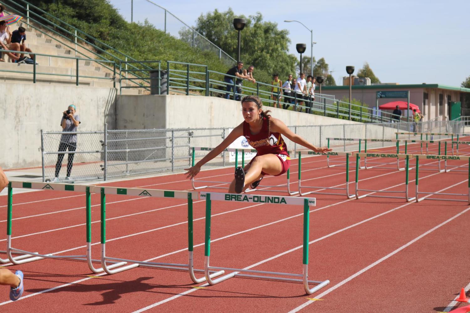 Junior%2C+Jacqueline+Chavez+jumping+over+a+hurdle+during+the+race.