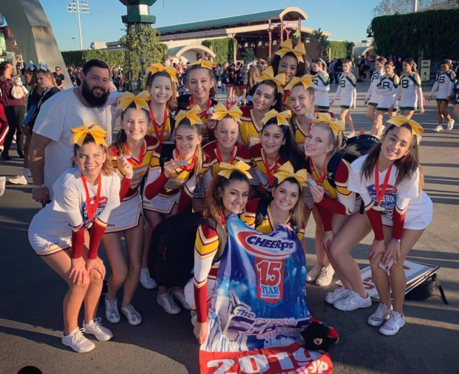 Cheer squad after competition celebrating their first place win with their banner. 