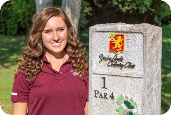 Senior Brianna Beauchamp smiles while standing next to the Yorba Linda Country Club par 4 sign.